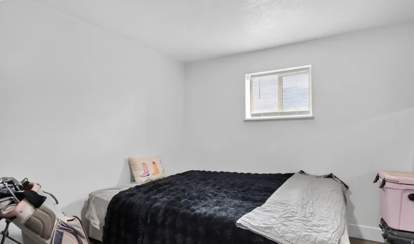 Unit 2B: White walls with a single window featuring horizontal blinds