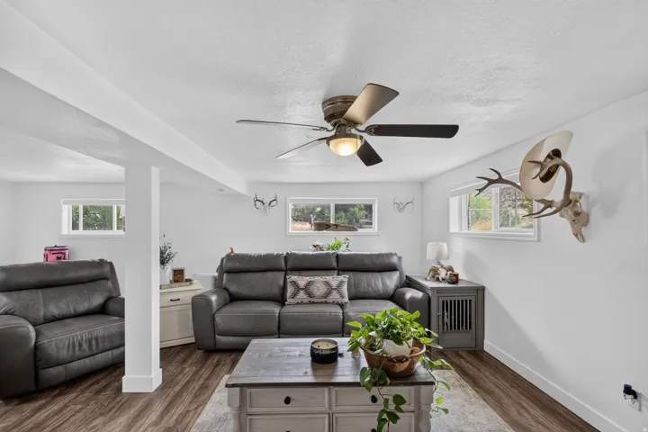 Unit 2B: Recessed windows, wood-finish flooring, ceiling fan with integrated lighting, and a structural support column