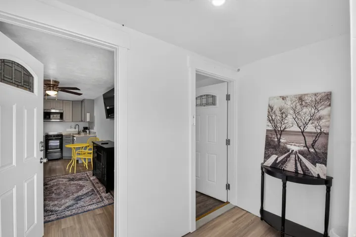 Unit 2A: Entryway with wood-finish flooring and a white paneled door with decorative glass