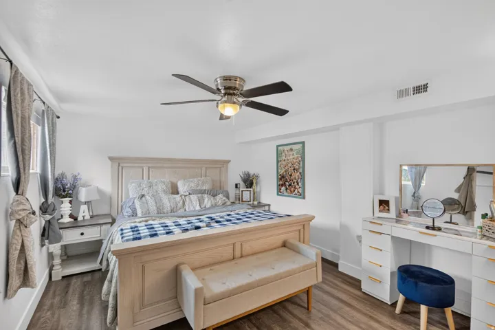 Unit 2B: Wood-finish flooring, white walls, and a ceiling fan with integrated lighting