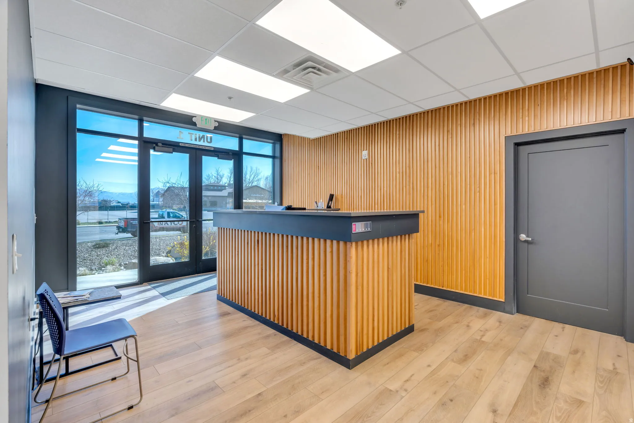 Welcome area with wood walls, a bar, expansive windows, and a paneled ceiling