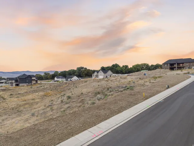Paved street and concrete sidewalk with a gently sloping property