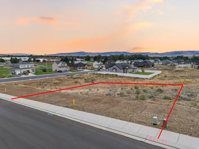 Expansive lot featuring a paved street, concrete sidewalk, and utilities installed at the property line
