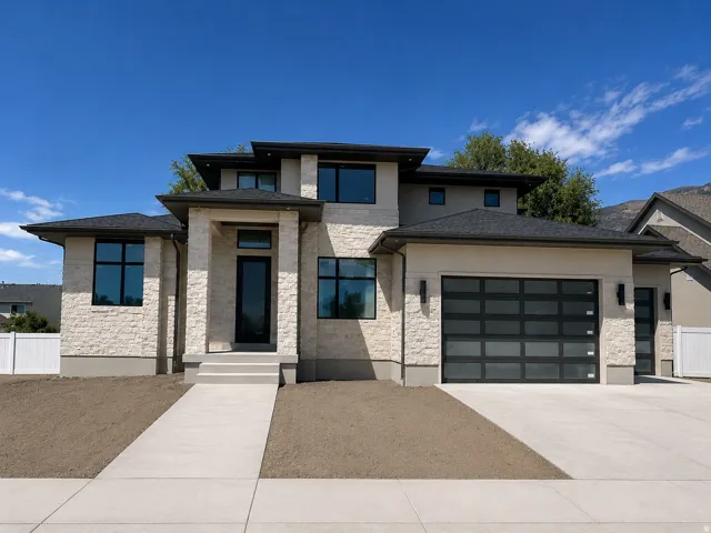 Modern exterior featuring a stone and stucco facade, a dark shingled roof, a contemporary front entry, and 3-car garage.  South facing home.