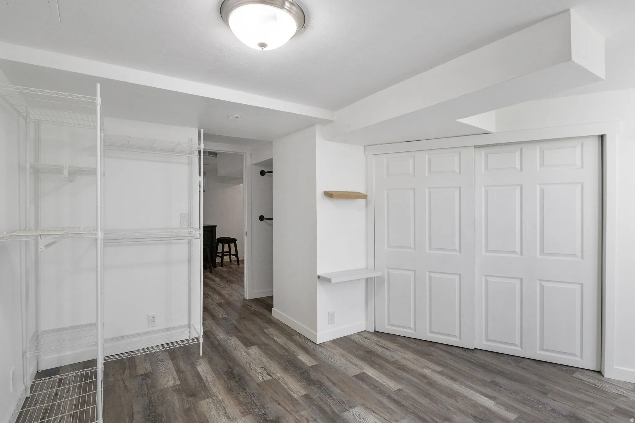 Bedroom 1 featuring dark vinyl floors a closet and additional storage