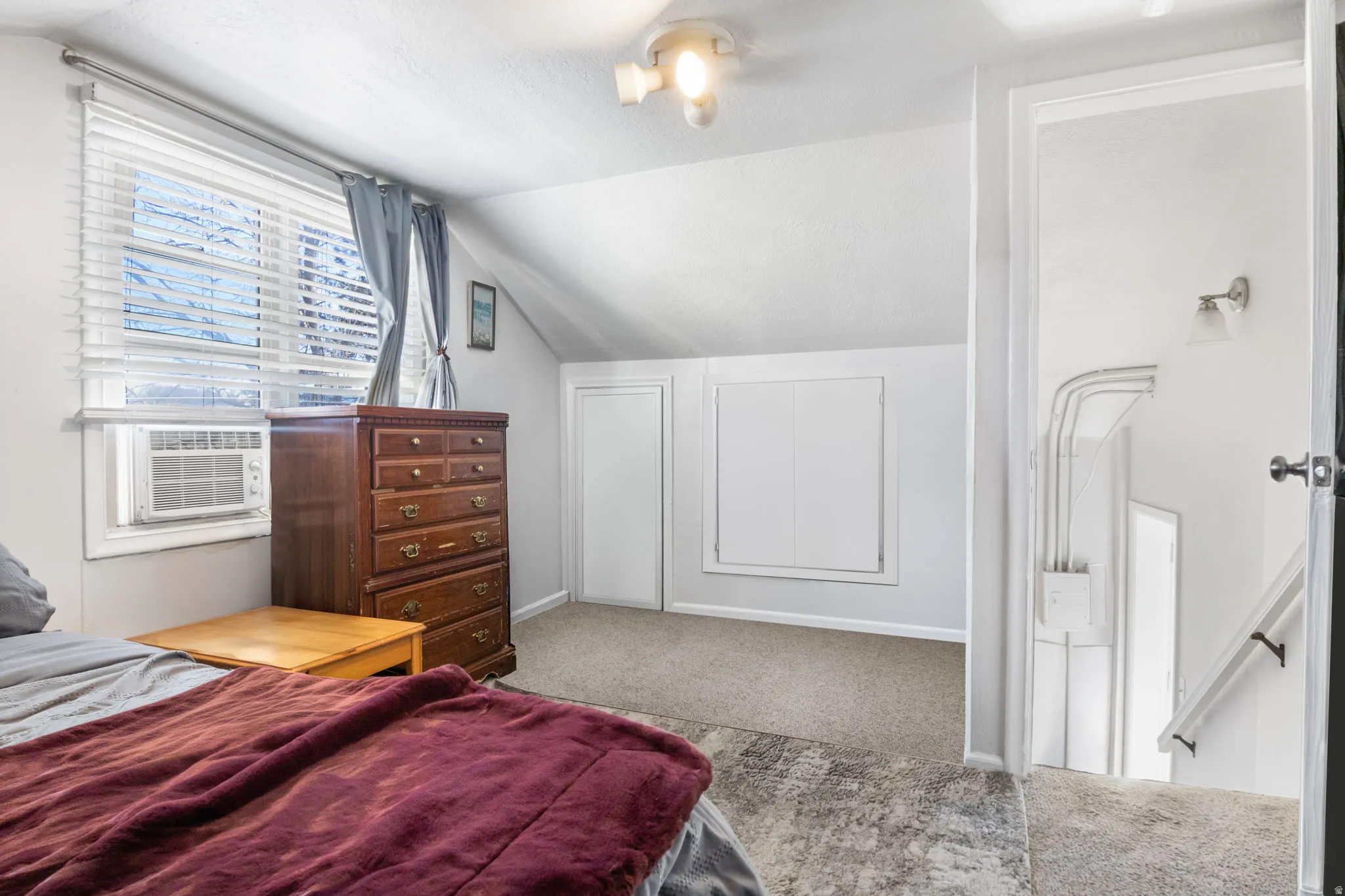 Bedroom 3 with vaulted ceiling, light carpet, and cooling unit