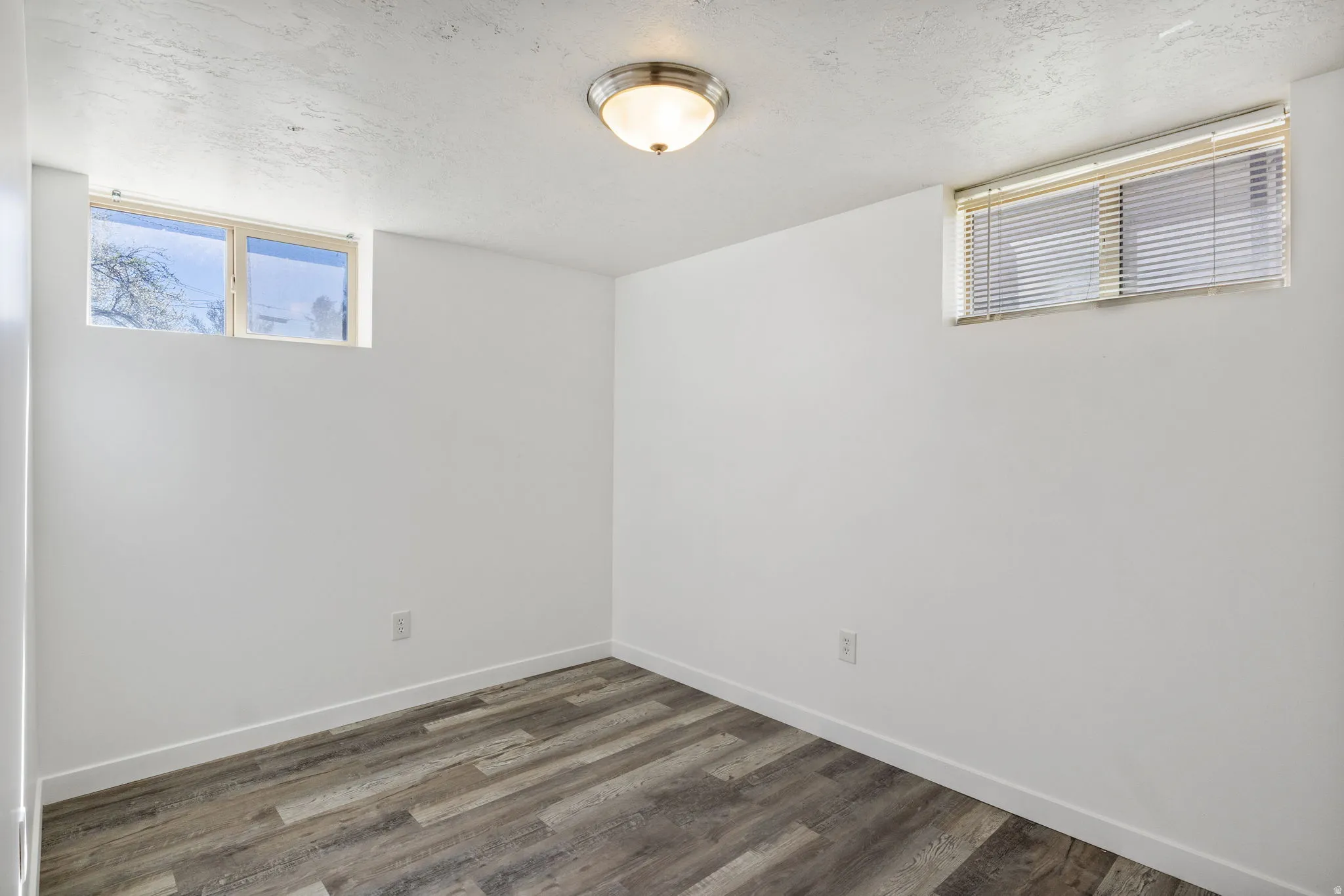 Bedroom 2 with dark vinyl flooring and a textured ceiling