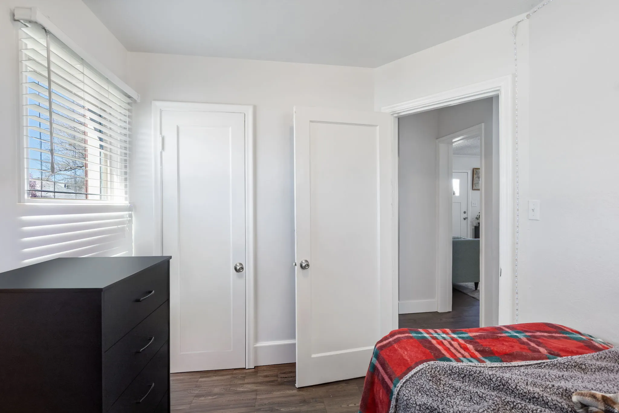 Bedroom 1 with dark wood finished floors and baseboards