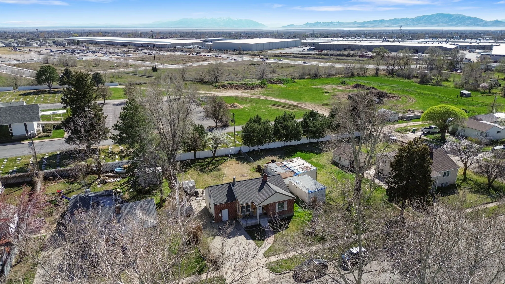 Aerial view of residential area featuring a mountain backdrop and industrial structures