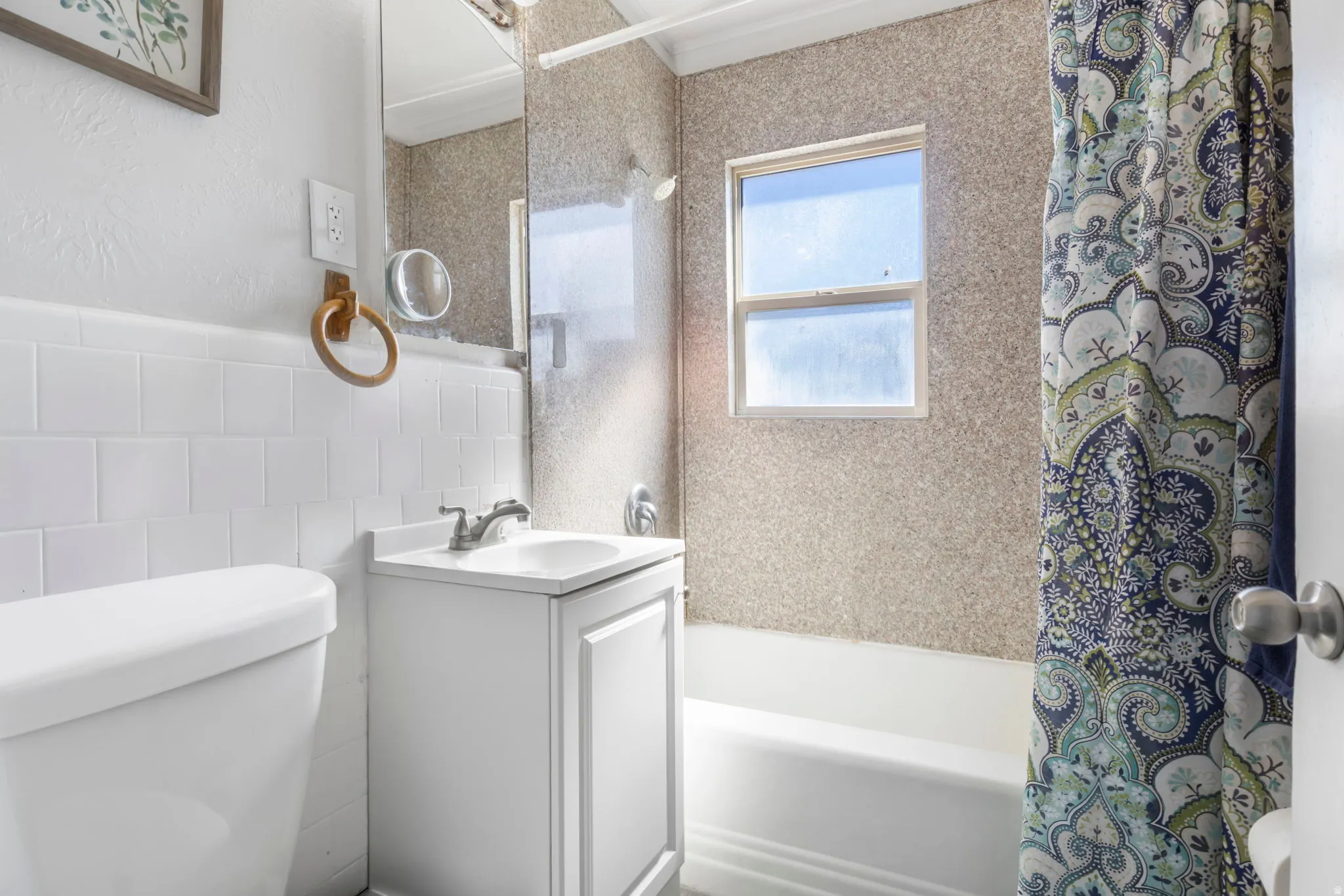 Bathroom with vanity, shower / bath combo, and a textured wall