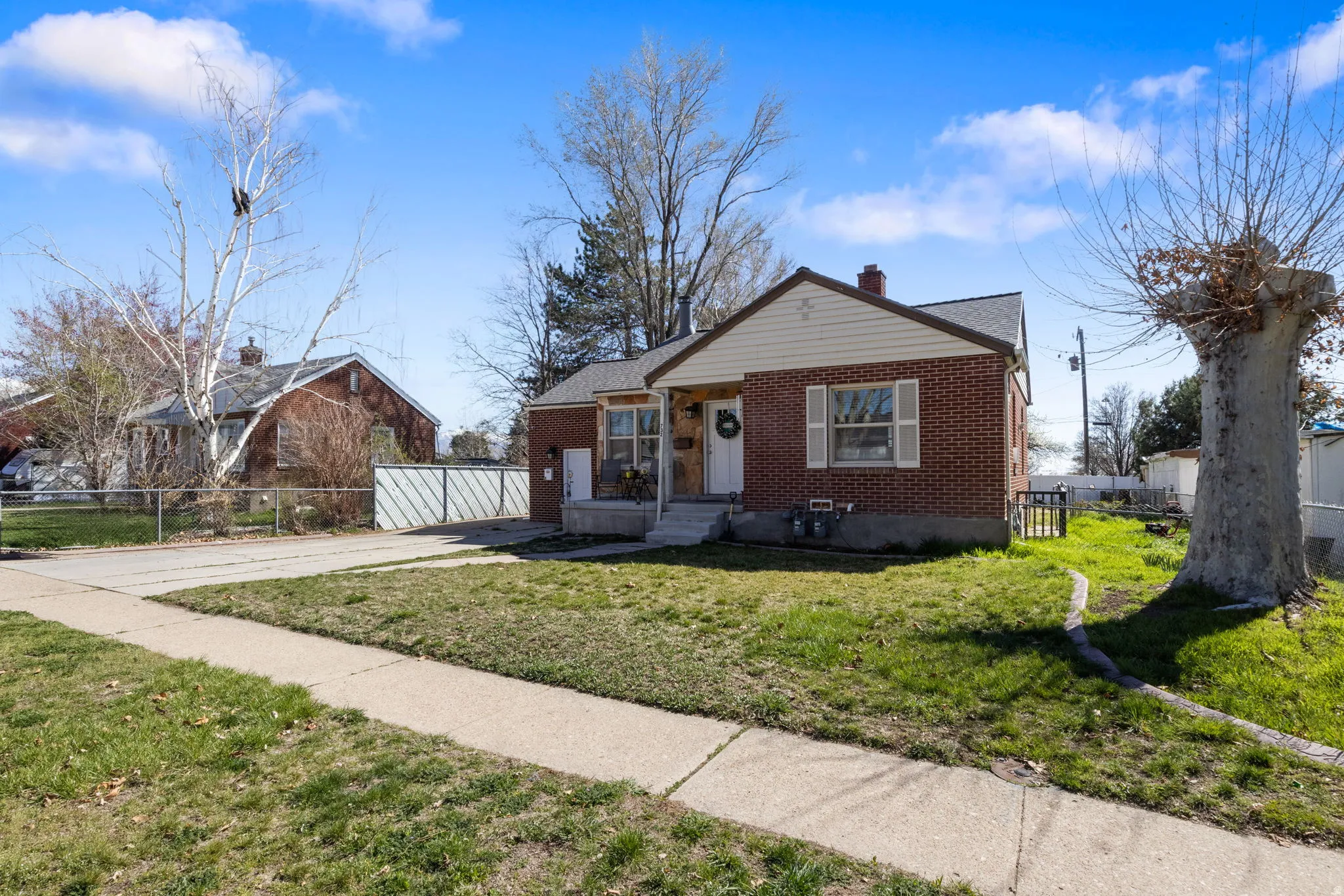 Bungalow featuring brick siding, a chimney, and driveway