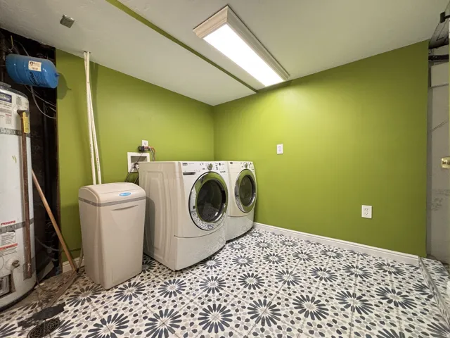 Laundry area featuring washer and dryer and strapped water heater