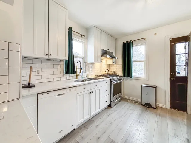 Kitchen featuring white cabinets, dishwasher, and stainless steel gas range oven