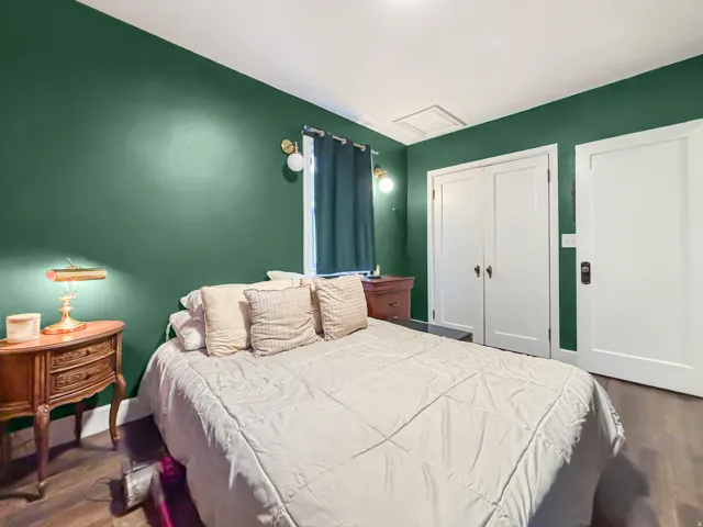 Bedroom with dark wood finished floors and a closet