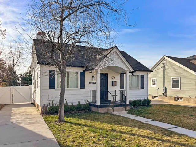 Bungalow-style house with a gate, a front yard, a chimney, roof with shingles, and a porch