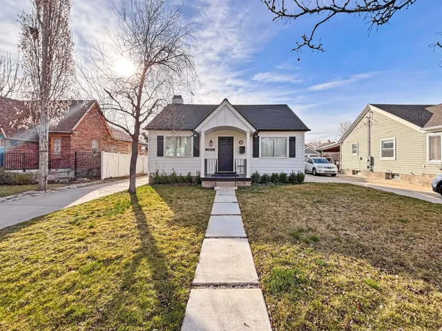 Bungalow-style home featuring a shingled roof, a chimney, and covered porch