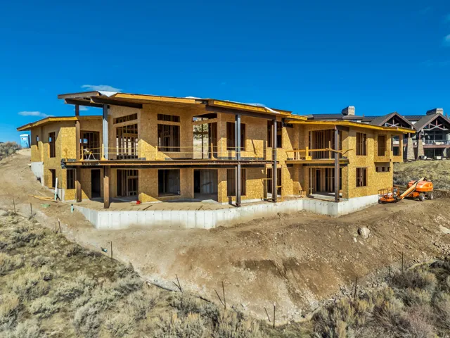 Rear view of house with a balcony, a patio area, and a metal roof