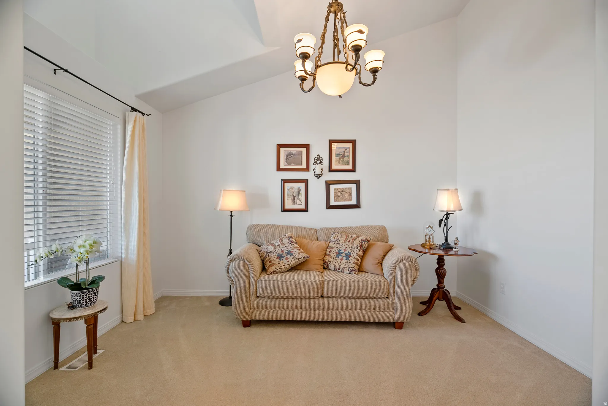 Living area with a chandelier, carpet, and lofted ceiling