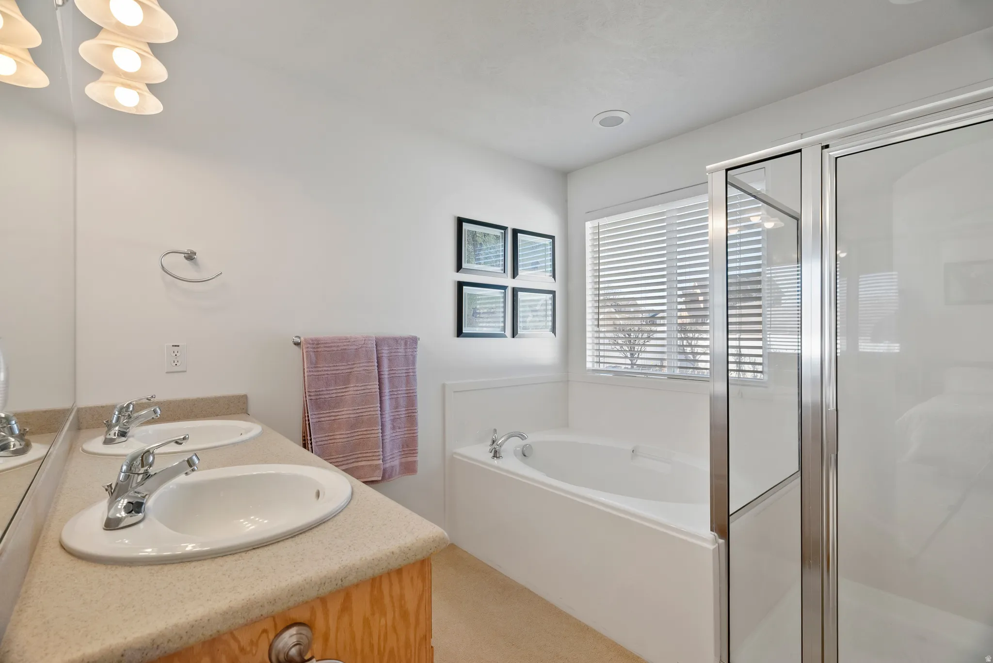Full bath with a stall shower, double vanity, and a garden tub
