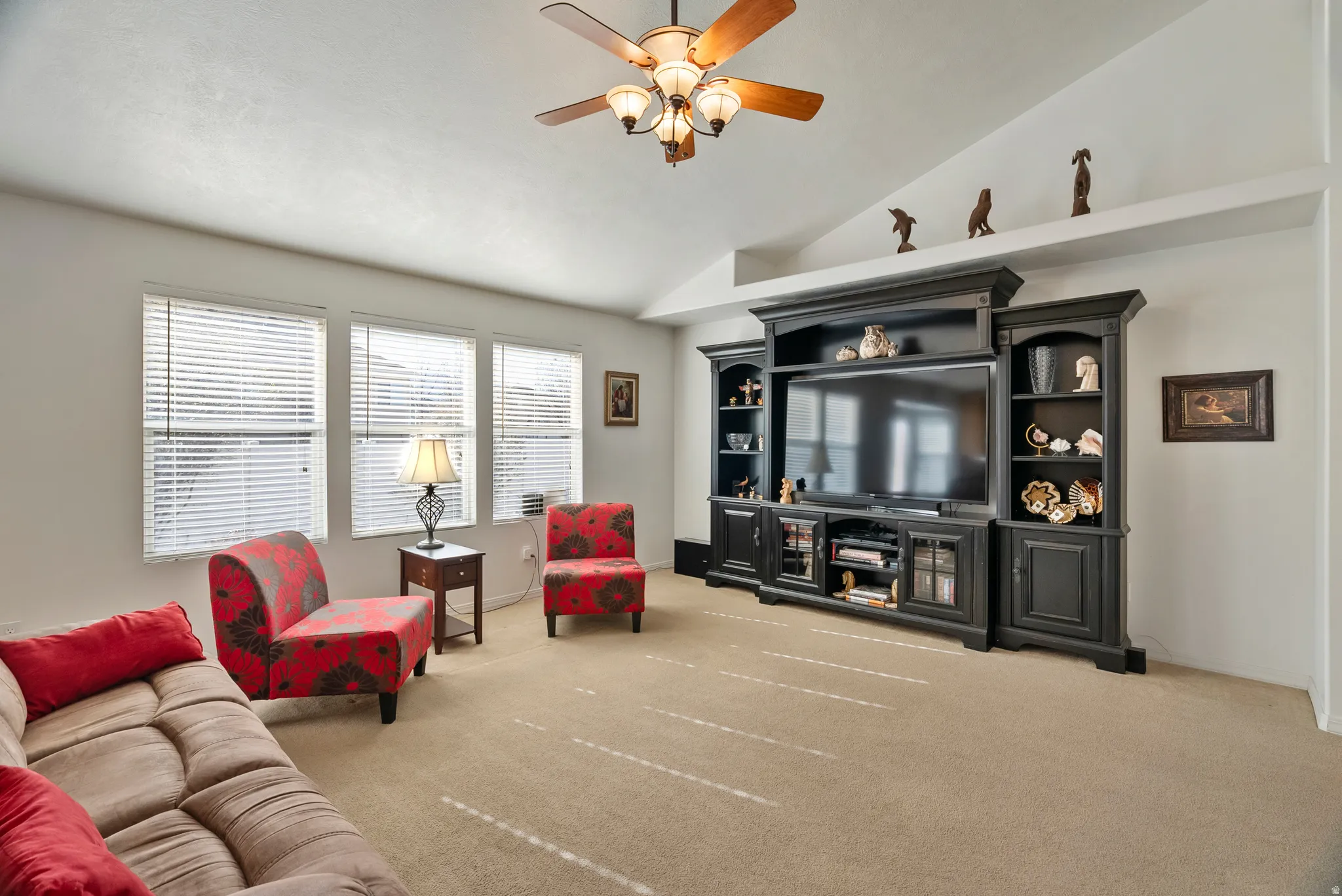 Living room featuring light carpet, a ceiling fan, and lofted ceiling