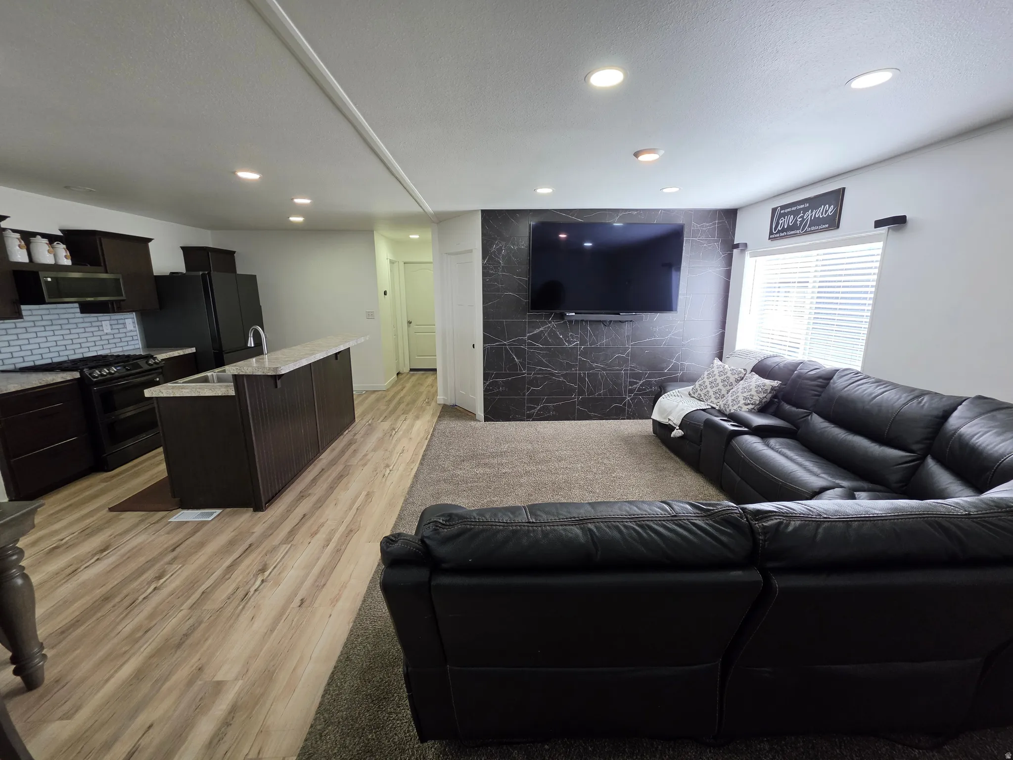Living room with light wood-style flooring and recessed lighting
