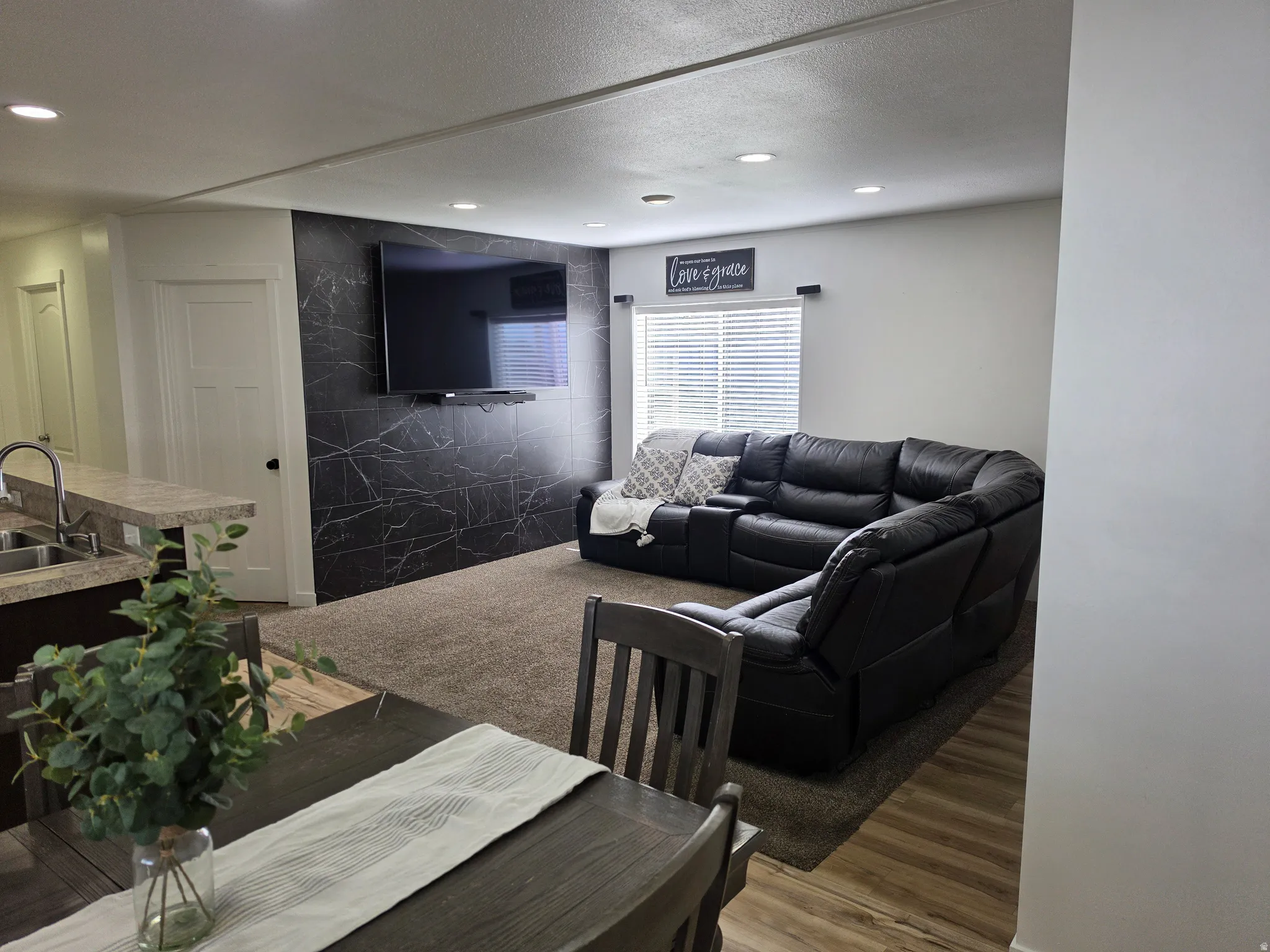 Living room with wood finished floors, recessed lighting, and a textured ceiling