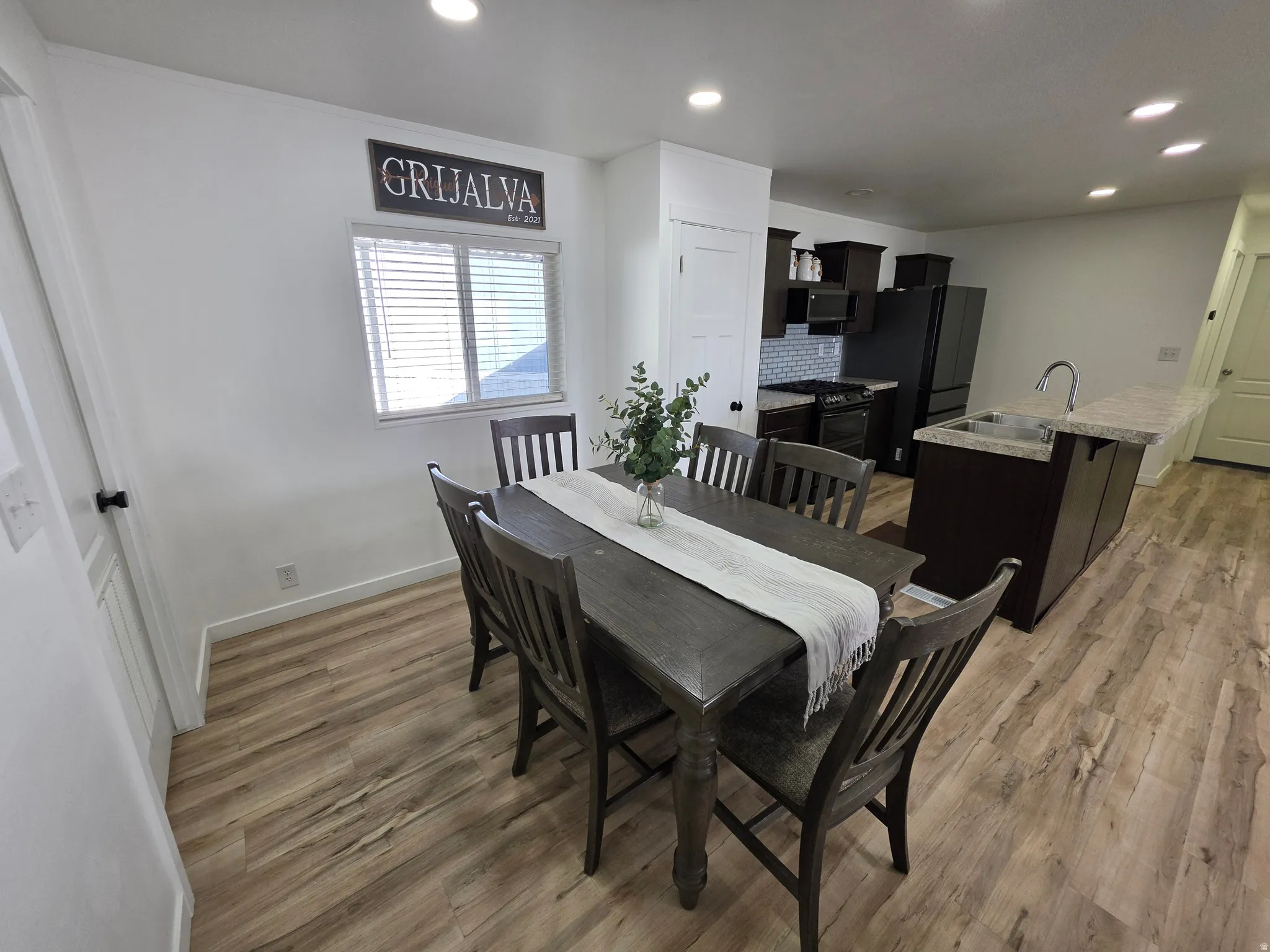 Dining area with light wood finished floors and recessed lighting