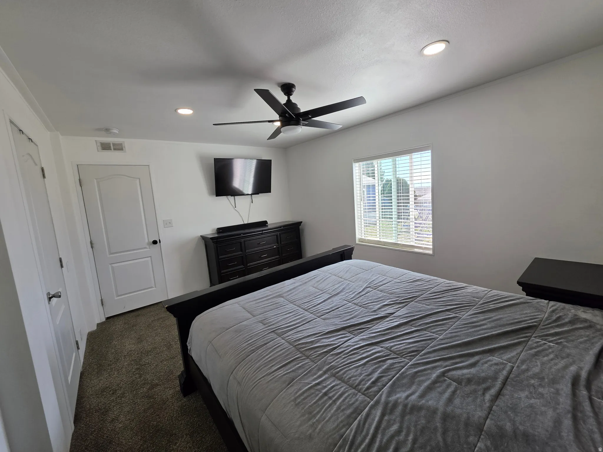 Bedroom featuring dark carpet, recessed lighting, and a ceiling fan