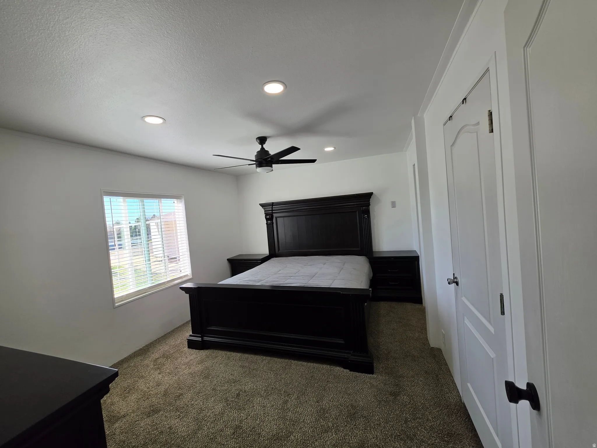 Bedroom featuring dark colored carpet, recessed lighting, and a ceiling fan