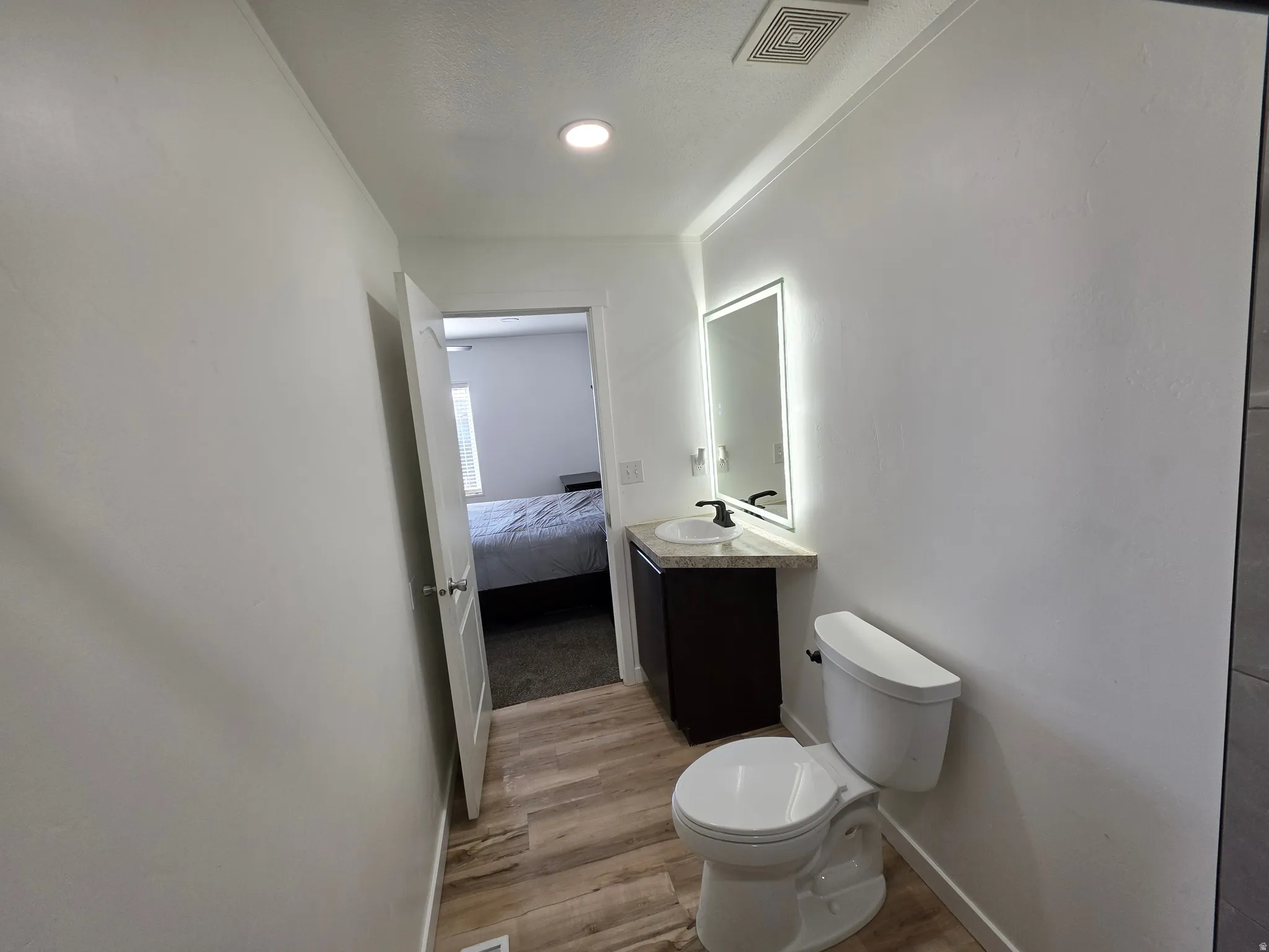 Ensuite bathroom featuring vanity and light wood-style floors