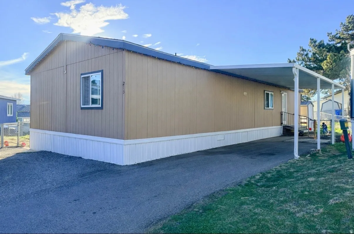 View of home's exterior featuring an attached carport and asphalt driveway