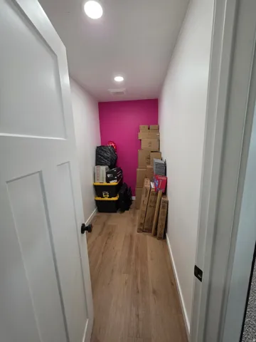 Corridor with light wood-style floors and recessed lighting