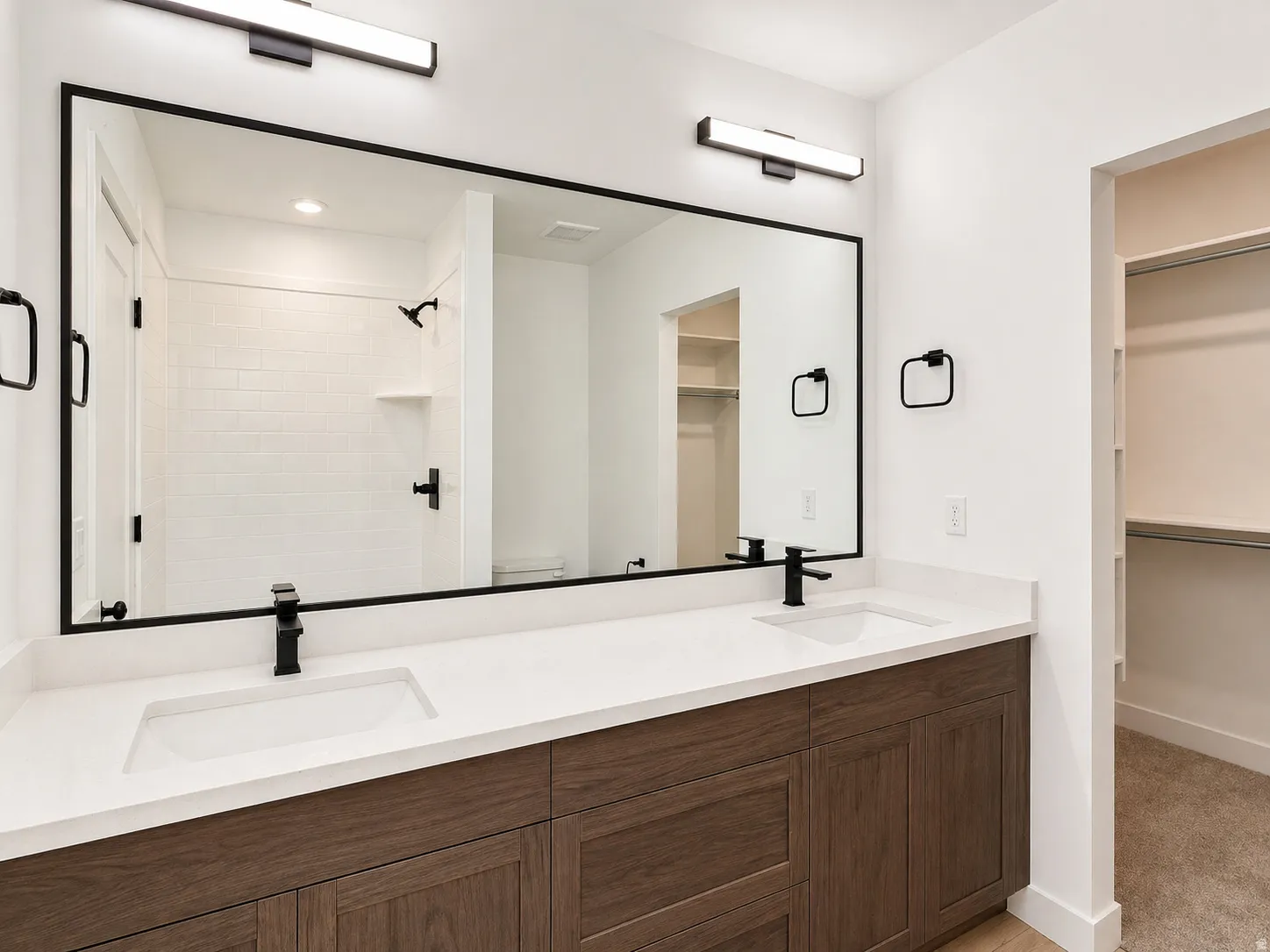 Dual vanity with wood-finish cabinetry and white countertops