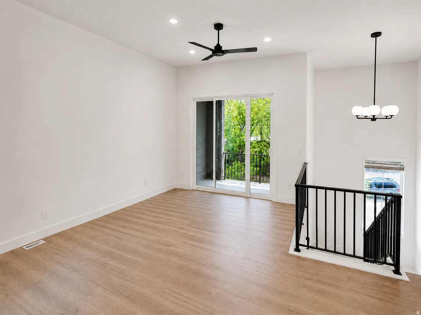 Open-concept living space featuring wood-finish flooring, recessed lighting, and a modern ceiling fan
