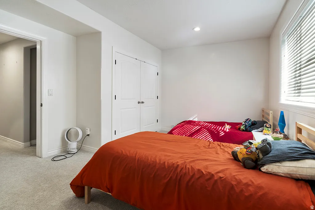 Bedroom featuring light carpet, a closet, and recessed lighting