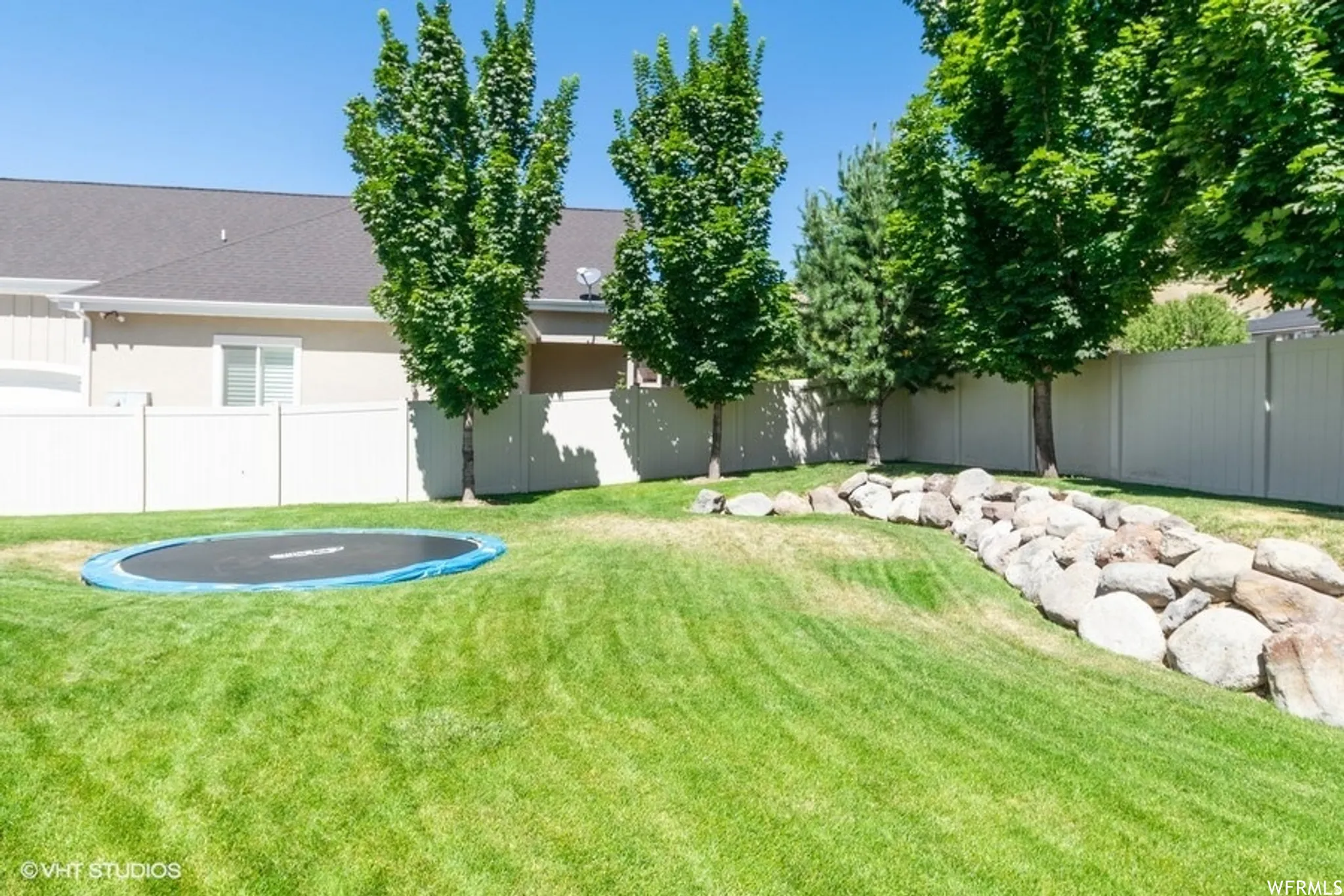 Last Summer - Fenced backyard with a trampoline