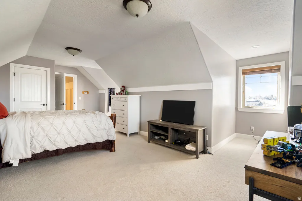 Bedroom featuring light colored carpet and baseboards