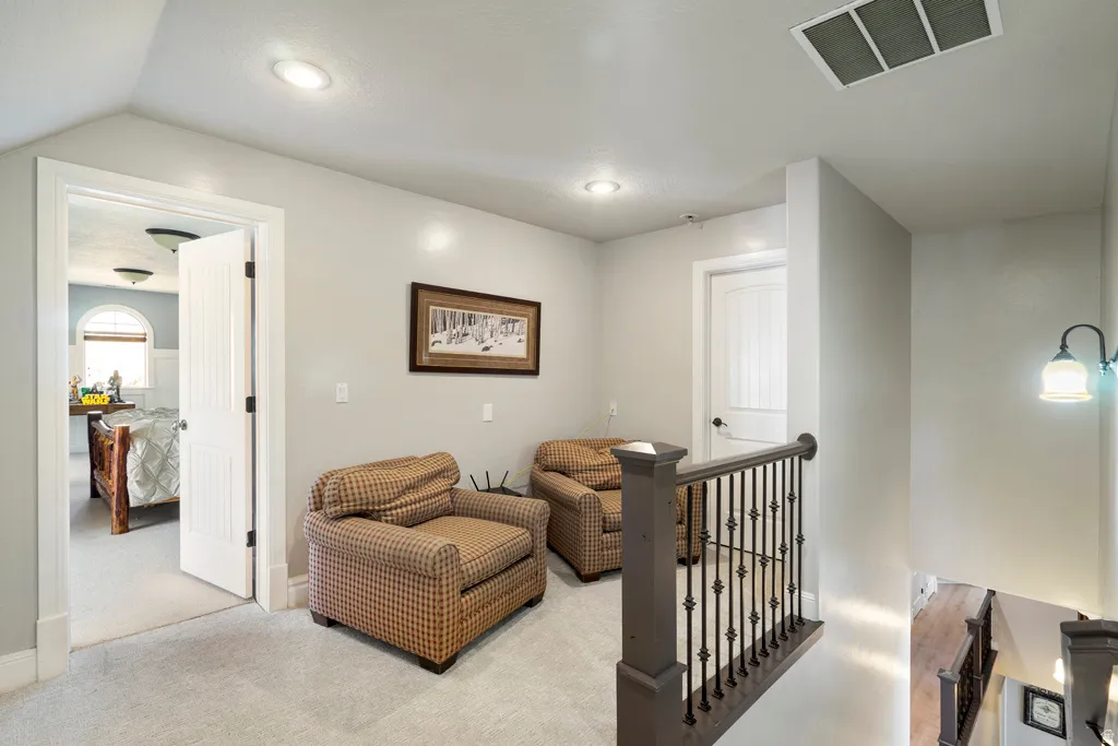 Sitting room featuring an upstairs landing and light colored carpet