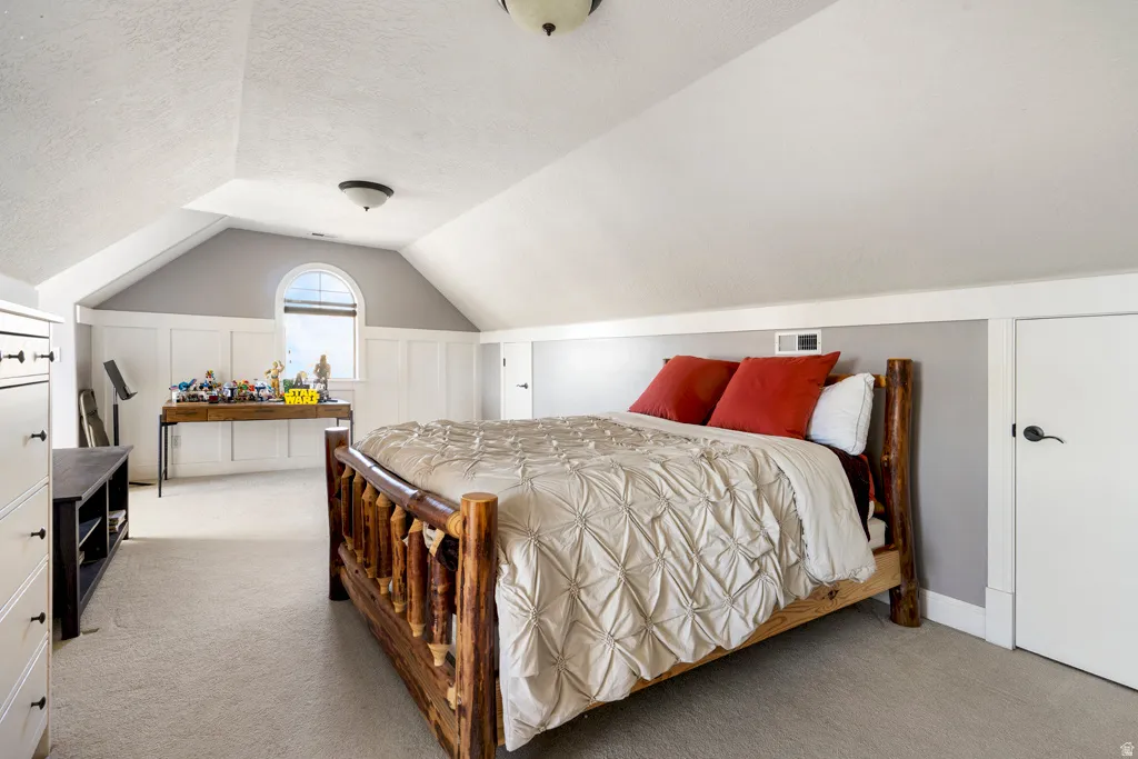 Bedroom featuring light colored carpet and a textured ceiling