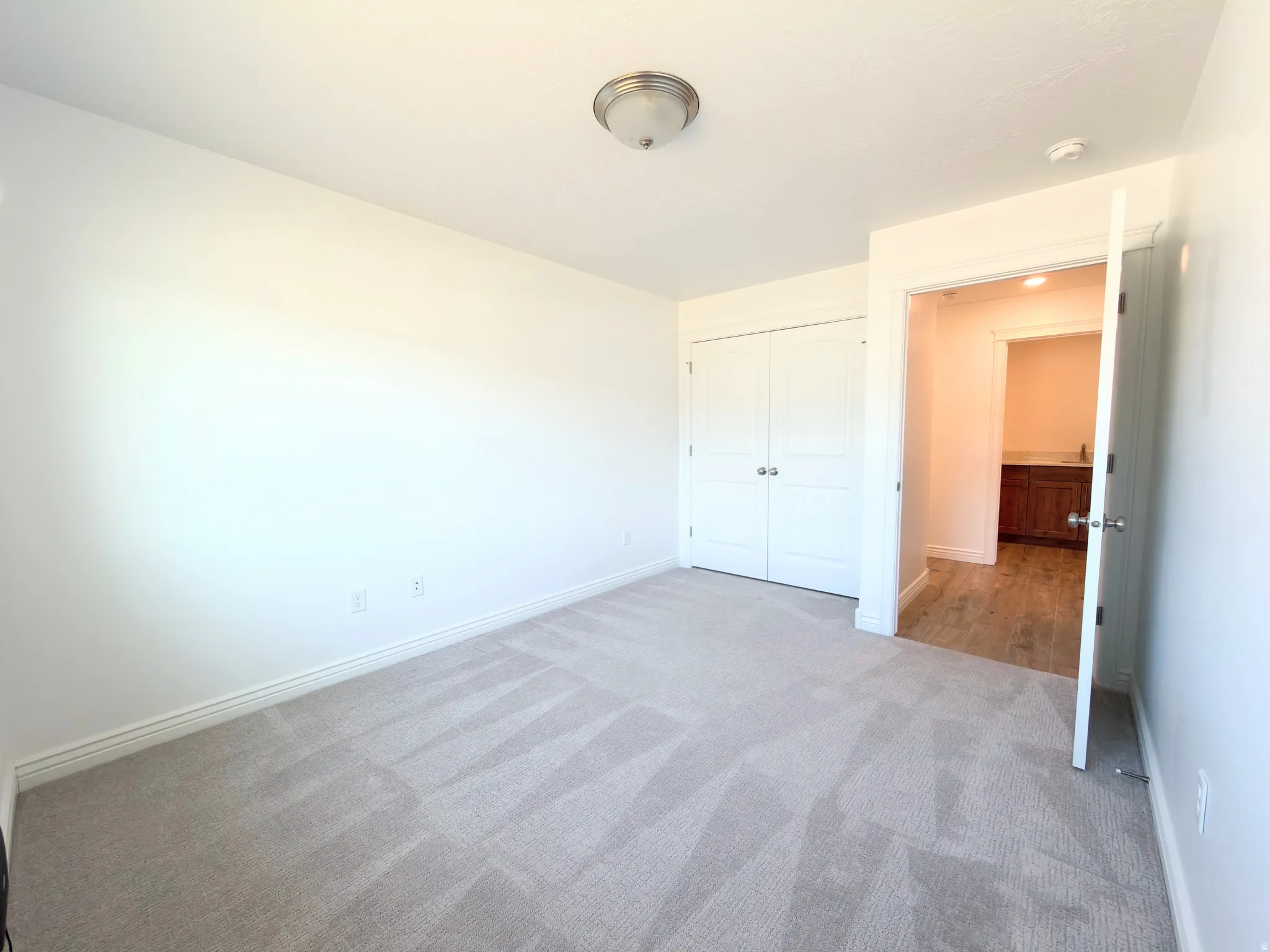 Unfurnished bedroom featuring light colored carpet and a closet