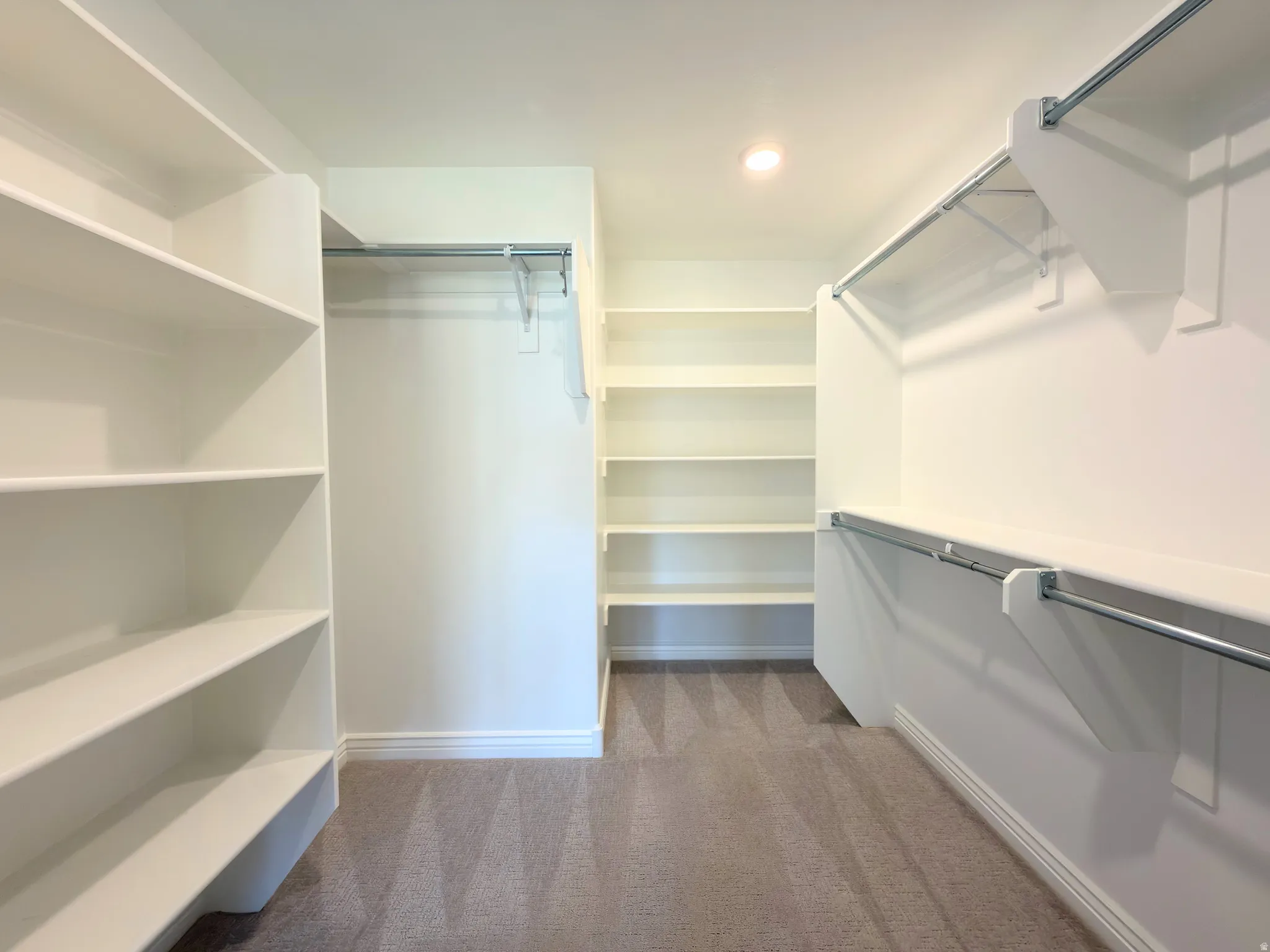 Walk in closet featuring dark carpet
