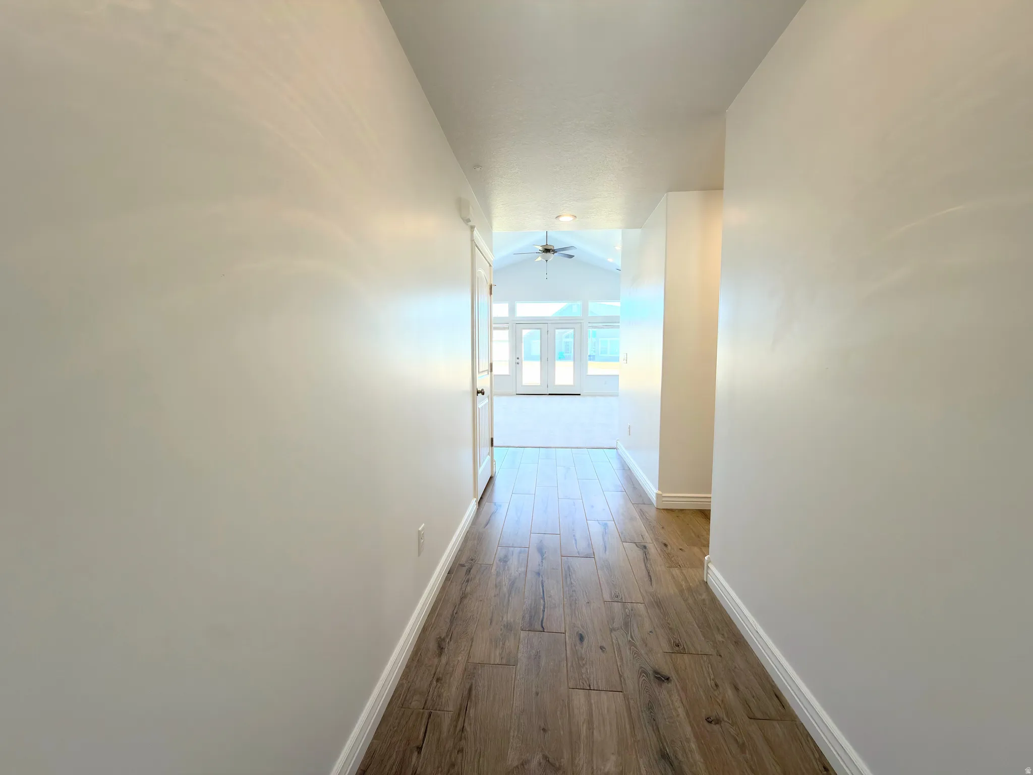 Hall with dark wood-type flooring and lofted ceiling