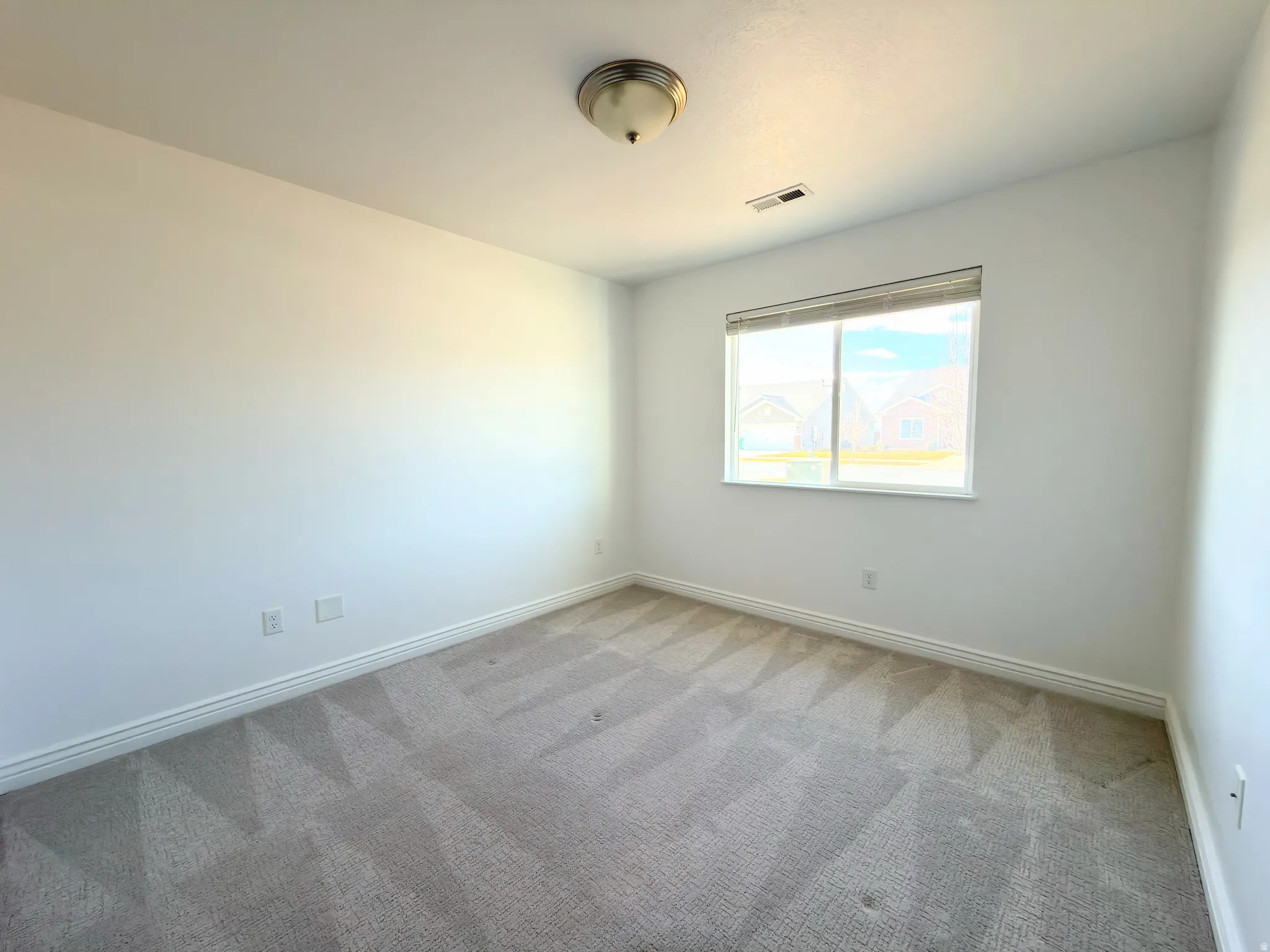 Unfurnished room featuring baseboards and light carpet