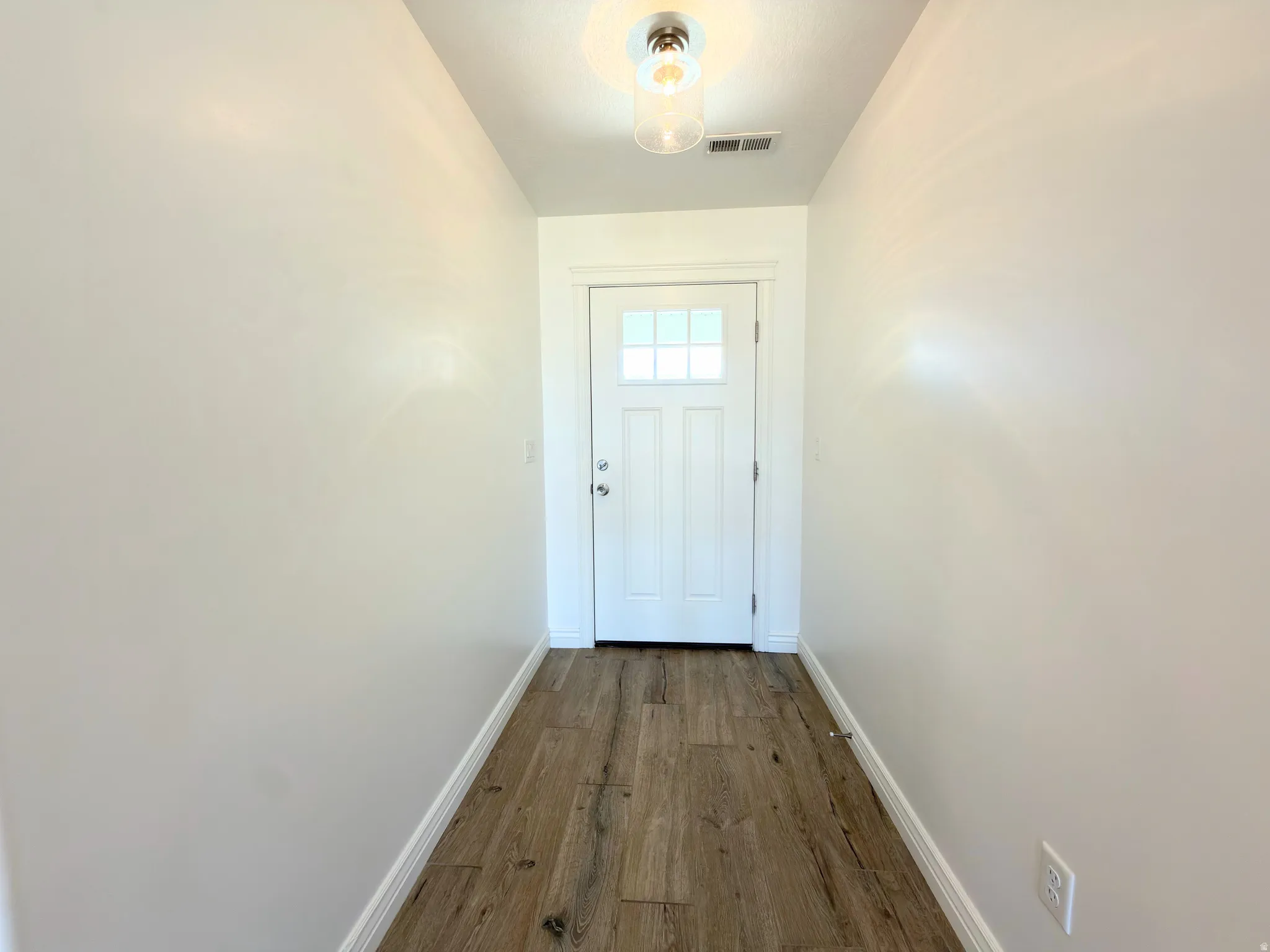 Entryway with wood-type flooring and baseboards