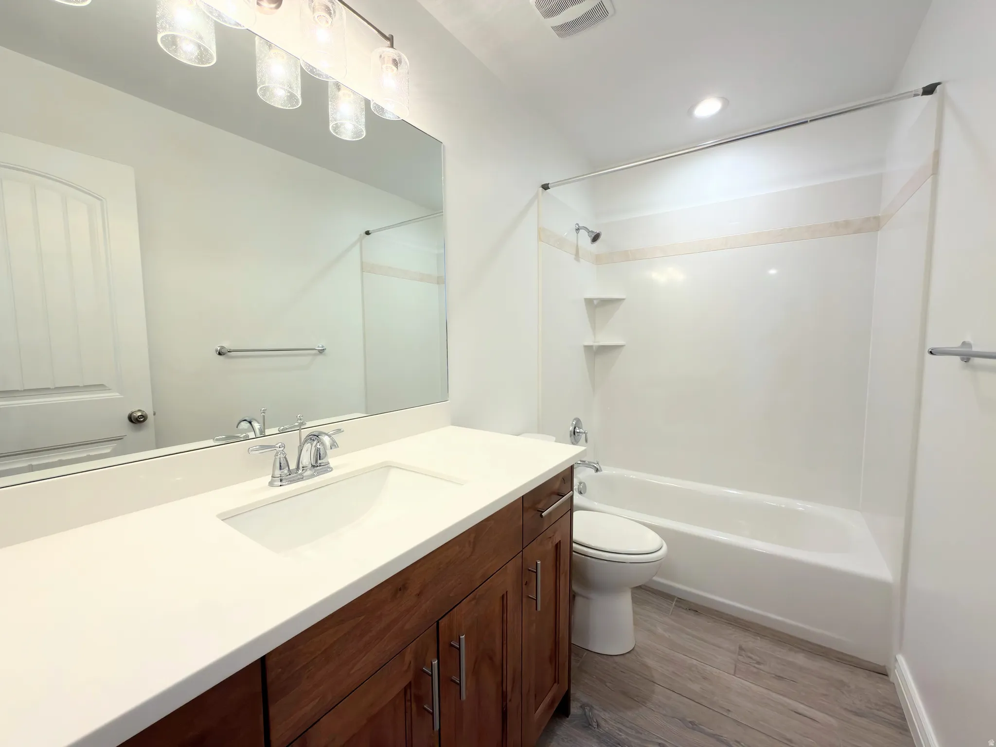 Full bath featuring vanity, light wood-style flooring, and shower / bath combination