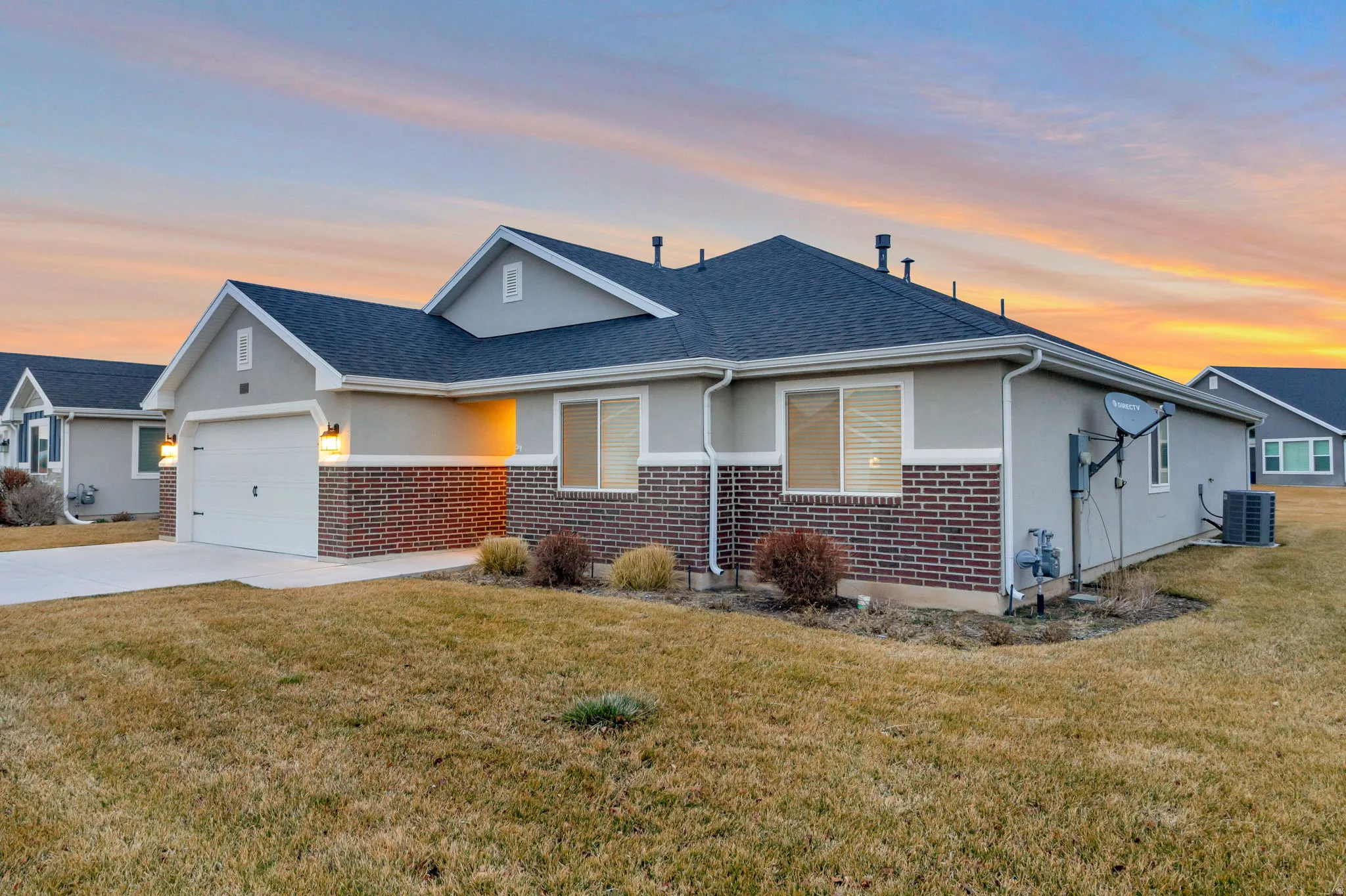 View of front of home with brick siding, a yard, and a garage