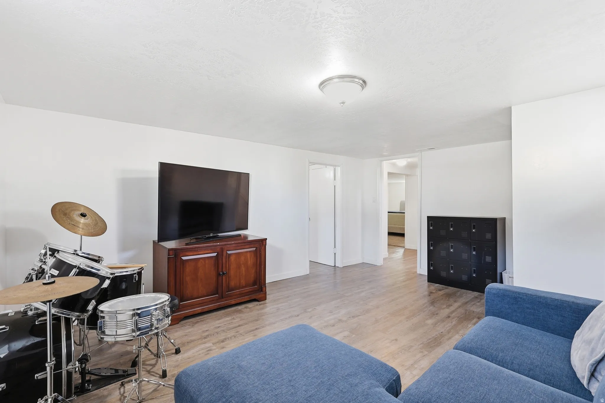 Living room with light wood-type flooring and a textured ceiling