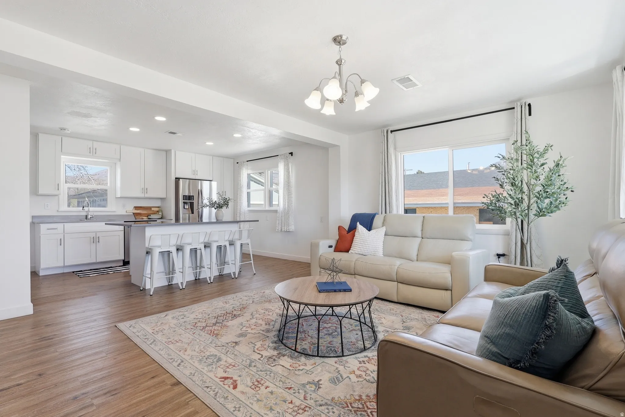 Living room featuring light wood finished floors and a chandelier