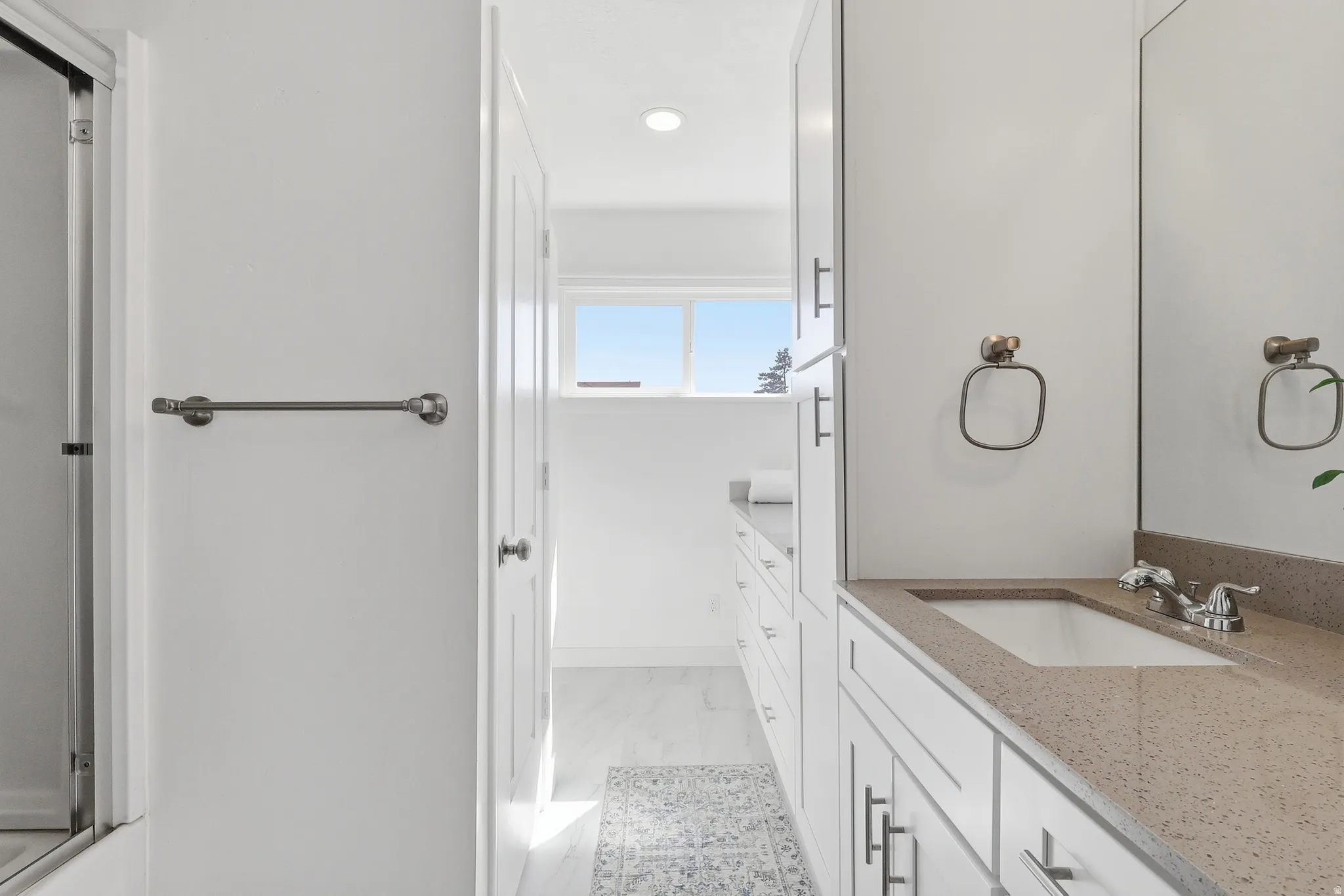 Bathroom featuring vanity, recessed lighting, and light marble finish flooring