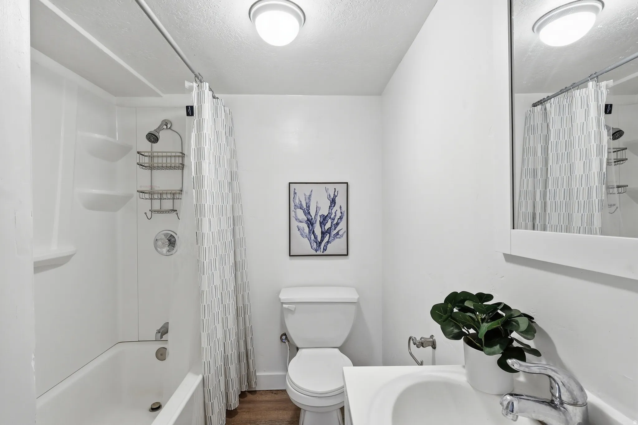 Full bath with shower / tub combo with curtain and a textured ceiling